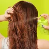 Model with Wavy Hair Applying e.l.f.'s Anti-Frizz Humidity Styling Spray