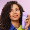 Model with Curly Hair Holding e.l.f.'s 3-in-Wonder Magic Hair Styling Cream