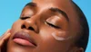 Model applying clear sunscreen to face